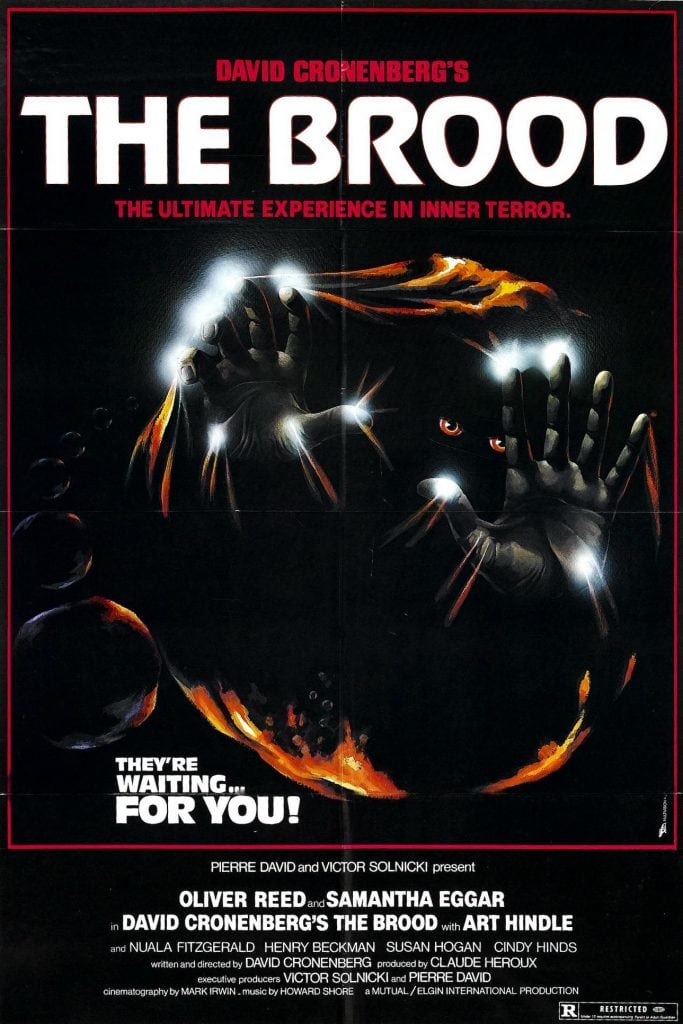 A dark, eerie poster for the film "The Brood" shows clawed hands breaking through a translucent barrier, with frightened eyes peering through. The text reads, "THE BROOD. They're waiting... for you!.