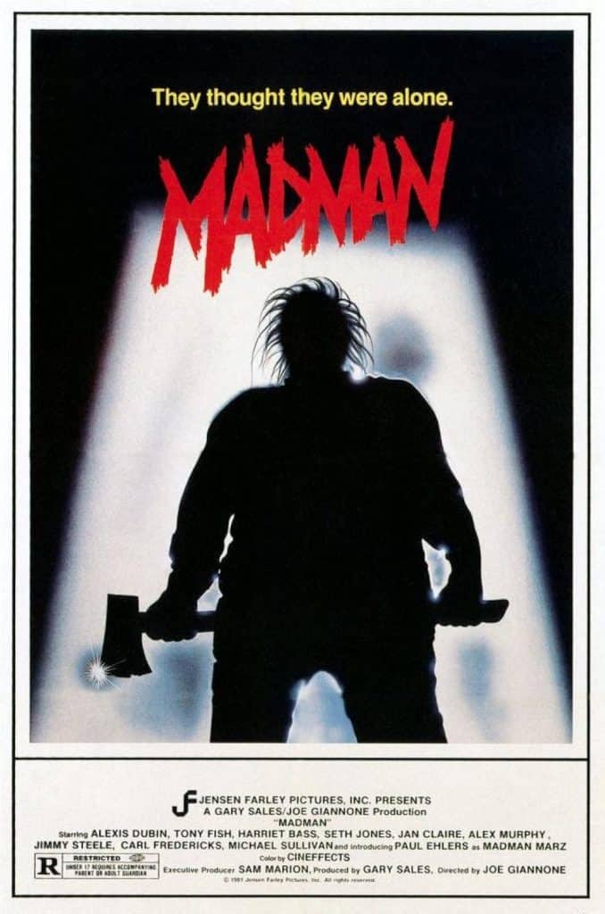 A movie poster shows the shadowy silhouette of a man holding an axe and another weapon, with wild hair. The text above reads “They thought they were alone.” and the title “MADMAN” appears in jagged red letters.