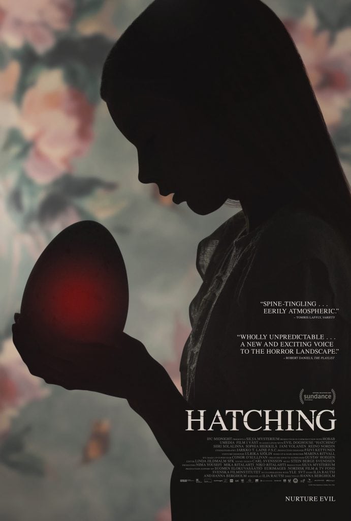 A silhouette of a girl holding a large, glowing red egg against a floral wallpaper background. Text on the image includes reviews, the film title "Hatching," and the tagline "Nurture Evil.