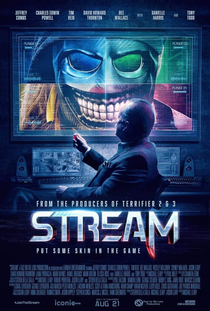 A person sits at a desk, watching multiple screens. One screen shows a sinister masked face, half human, half skull. The movie title "STREAM" and tagline "Put Some Skin in the Game" are displayed below.