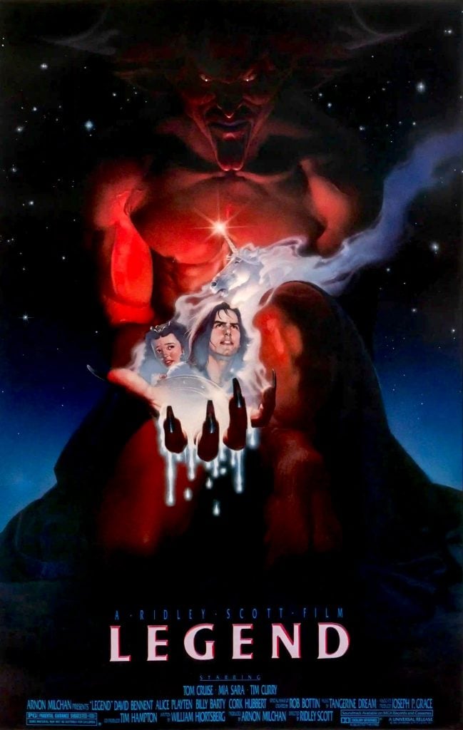 A dark fantasy movie poster shows a giant red demon looming over a glowing crystal ball with two human faces inside, surrounded by smoke and stars. The title “Legend” appears at the bottom.