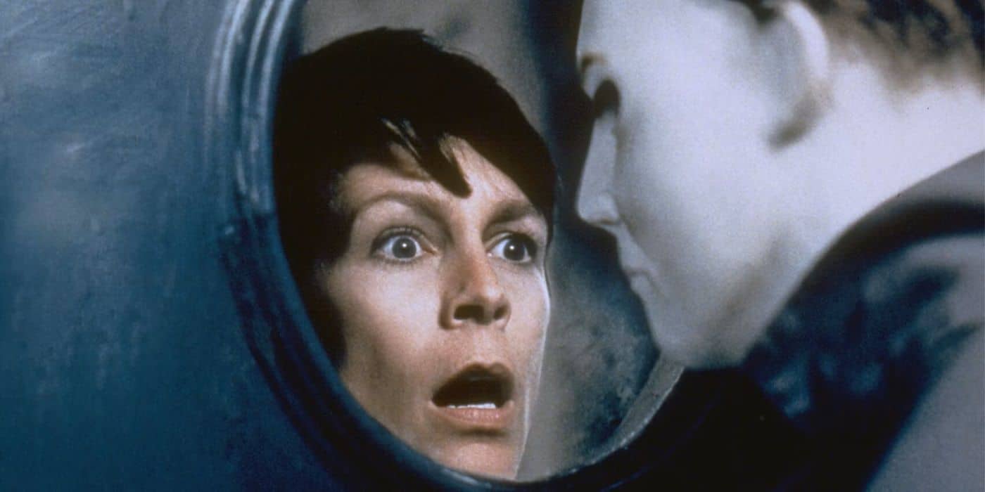 A terrified woman with short dark hair stares through a circular window at a blank-faced figure in a white mask, evoking the tense and suspenseful atmosphere of a classic cult film or vintage horror movie.